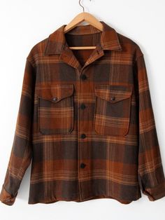 A 1960s vintage wool shirt jacket. The thick wool jacket features a tan, dark brown, and gold plaid. There are button pockets on the chest, and single button closures at the cuff. It buttons closed. The jacket is unlined. CONDITIONIn great condition. There is a small mark on the right chest pocket.Approximate Fit: Men's Large, 46MEASUREMENTSBust:  49" ....  124.5 cmLength:  28.5"  ...  72.4 cmShoulders:  20"  ....  50.8 cmSleeves: 34"  ...  86.4 cmOuter Sleeve: 24"  ...  61 cmHOW WE MEASURE• Jac Mens Brown Coat, Brown Flannel, Checkered Jacket, Wool Shirt, Brown Coat, Hornet, Wool Plaid, Looks Vintage, Retro Outfits