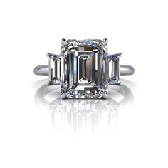 Emerald cut three stone moissanite engagement ring, perfect for engagement or anniversary3.50 ct. 10x8mm, emerald cut colorless moissanite, DEF Color, VVS Clarity.(2) 5x2.5mm, step cut baguettes, colorless moissanite, DEF Color VVS Clarity, .33 ct.*Engagement Ring Band width 2mm.*4.16 carat total weight.. *Your moissanite stone purchase will arrive with a warranty card/certificate of authenticity. *The ring is custom made just for you in your ring size and metal preference. *925 Silver is rhodiu Emerald Cut Lab Grown Diamond Jewelry For Anniversary, Emerald Cut Moissanite Diamond Ring, Emerald Cut Lab Grown Diamond Fine Jewelry, Fine Jewelry Emerald Cut Lab Grown Diamond, Fine Jewelry With Emerald Cut Lab Grown Diamond, Moissanite Jewelry With Emerald Cut Center Stone, Diamond White Moissanite Emerald Cut Ring, Diamond White Three-stone Emerald Cut Jewelry, Emerald Cut Lab Grown Diamond Jewelry With Center Stone