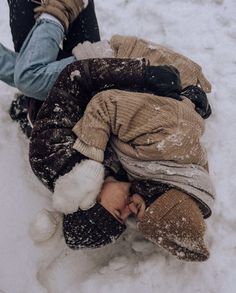 a person laying in the snow with their feet on his back and hands behind him