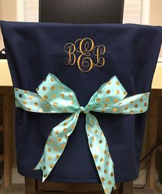 a blue chair with gold polka dots and a monogrammed bow