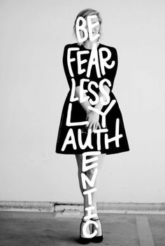 a woman is holding a sign that says be fear less, laugh everything