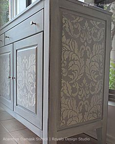 the sideboard is painted gray and has an intricate design on it's doors