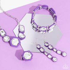 A vivid, faceted, white gem is pressed into the center of a hexagonal purple rubber-like frame, creating a powerful pop of color atop the finger. Features a stretchy band for a flexible fit.

 Sold as one individual ring.

Get The Complete Look!
Bracelet: "Transforming Taste - Purple" (Sold Separately)
Earring: "Developing Dignity - Purple" (Sold Separately) Gunmetal Ring, Gray Earrings, Purple Rings, Brown Bracelet, Purple Bracelet, Brown Necklace, Orange Earrings, Red Necklace, Purple Earrings