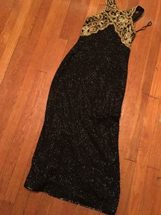 "Gorgeous black and gold evening gown by Laurence Kozar. Tag size medium Measurements: 36\" bust 50.5\" length There is one small area where the beading has come off on the front side of the dress toward the thigh. It's not very noticeable, see photos attached." Gold Gown With Fitted Bodice For Night Out, Gold Evening Dress With Fitted Bodice For Night Out, Fitted Gold Sequin Dress For Prom Season, Gold Fitted Maxi-length Sequin Dress, Gold Fitted Gown With Sequins, Gold Fitted Sequin Dress For Homecoming, Gold Floor-length Sequin Dress For Night Out, Fitted Gold Sequin Homecoming Dress, Fitted Gold Evening Dress For Homecoming