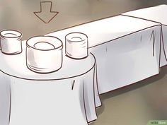 a table with white cloth and two cups on it, next to an arrow pointing up