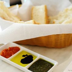 bread and dipping sauces in small dishes on a table