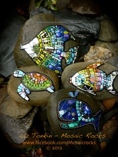 mosaic fish sitting on top of some rocks