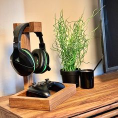 a desk with headphones and a plant on it