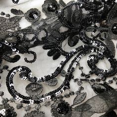 black and white lace with flowers on it is seen in this close up photo,