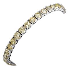 This exquisite bracelet features 11.00 carats of natural colored round brilliant fancy yellow and light yellow diamonds, set in 14 kt white gold. The vibrant yellow hues of the diamonds are beautifully complemented by the sleek white gold setting, creating a piece that exudes luxury and elegance. Certified by GCI for quality and authenticity, this bracelet is a dazzling addition to any jewelry collection, perfect for adding a touch of sophistication and brilliance to any occasion. Side Stones: ___________ Natural Diamonds Cut: Round Brilliant Carat: 11.00 cttw / 45 stones Color: Light Yellow - Fancy Yellow Clarity: SI-i1 Size: 18 cm Item ships from Israeli Diamonds Exchange, customers are responsible for any local customs or VAT fees that might apply to the purchase. **Import duties and ta Bracelet Art, Yellow Hues, Diamond Mines, Yellow Diamonds, White Gold Bracelet, Fancy Diamonds, Art Deco Diamond, Yellow Diamond, Tennis Bracelet