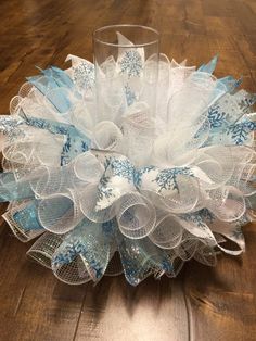 a glass vase sitting on top of a wooden table next to a snowflake decoration