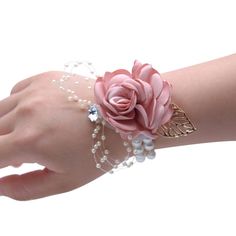 a woman's hand wearing a pink flower and pearl bracelet with pearls on it