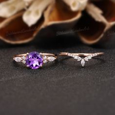 two rings with an amethorate and diamonds on the side, next to some flowers