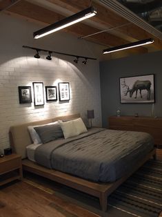 a large bed sitting in a bedroom next to two pictures on the wall above it