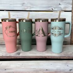 three different colored tumblers with straws in them on a wooden shelf next to a wall