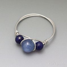 a silver ring with two blue beads on it