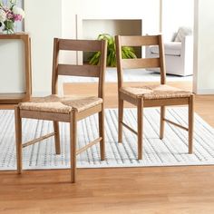 two wooden chairs sitting on top of a white rug