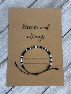 "Always and Forever" Morse Code Bracelet. A daily reminder that you are with your special recipient.  This bracelet is made with high quality, black waxed cotton cord - which is durable and lightweight. Beautiful black & white glass seed beads are used for your message.  Bracelet is adjustable with a sliding knot that fits most wrist sizes. Bracelet comes shipped with card stock packaging as shown.  Want a customized morse code bracelet? Message me and I can create it for you! Black Inspirational Friendship Bracelets, Inspirational Black Friendship Bracelets, Meaningful Black Jewelry For Mother's Day, Personalized Black Friendship Bracelets For Mother's Day, Personalized Inspirational Black Bracelets, Inspirational Personalized Black Bracelets, Black Beaded Bracelets For Mother's Day Gift, Black Friendship Bracelets For Mother's Day, Adjustable Black Beaded Bracelets For Mother's Day