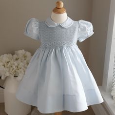 This Light Blue Smocked Baby Girl's Heirloom Dress Is Precious!! Done By Feltman Brothers (Fine Children's Apparel), This Little Dress Has Details Galore!! The Entire Bodice Is Smocked And Has A Lattice Design Embroidery Done In A Blue Threading. Just Above The Gathers Of The Waist Is A Blue Embroidered Chevron Border. Just Above That Is A Gorgeous Hand-Embroidered Garland Of Blue And White Floral Wreaths. The Short Puff Sleeves Have A Double Trim Hem, Joined Together By Hand-Faggoted Stitches ( Feltman Brothers, Baby Pageant, Smocked Dresses, Smocked Baby Clothes, White Baby Dress, Heirloom Portraits, Hand Smocked Dress, Heirloom Dresses, Wedding Options