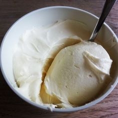 a white bowl filled with ice cream on top of a wooden table