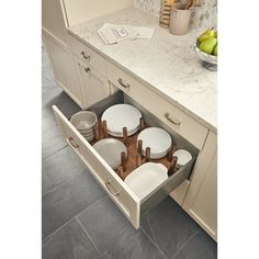 an open drawer in the middle of a kitchen with plates and utensils inside