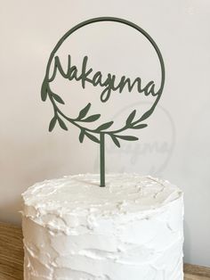 a white cake with green leaves and the word kalagana on it's top