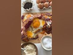 an image of some food on a table with eggs and other foods in bowls next to it