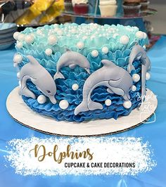 there is a blue and white cake with dolphins on it