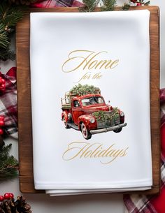 an old red truck with a christmas tree on the hood is sitting in front of some pine cones