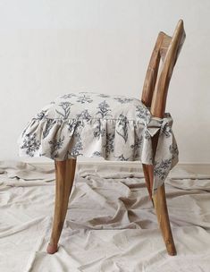 an upholstered wooden chair sitting on top of a white sheet