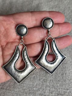 A pair of vintage, sterling silver boho chic drop earrings. These earrings have such a statement presence as they are long and large. They are slightly hammered and have am oxidized effect. They measure 7.1x4.3cm and have a combined weight of 15.05g.  The top portion of these earrings are a round shape stud. A dramatic diamond shape dangles from the stud. All edges of the earrings have a rope design, which create a wonderful textual contrast with the hammered surface.  The earrings are oxidized Silver Hammered Bohemian Earrings, Bohemian Hammered Sterling Silver Earrings, Bohemian Sterling Silver Hammered Earrings, Bohemian Silver Hammered Earrings, Traditional Hammered Silver Earrings, Traditional Silver Hammered Earrings, Boho Drop Earrings, Silver Statement Earrings, Earrings Large