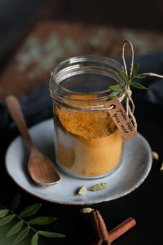 a glass jar filled with liquid sitting on top of a plate next to cinnamon sticks