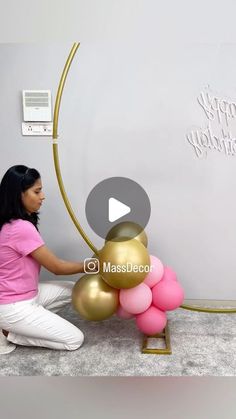 a woman sitting on the floor with balloons in front of her