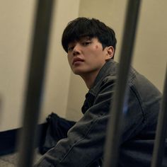 a young man sitting on the floor in front of a mirror