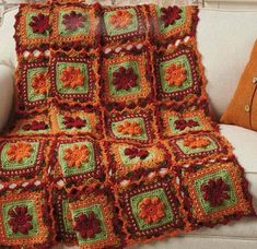 a crocheted afghan is sitting on a couch next to a pillow and pillows