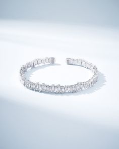 Suzanne's signature design is on full display with this exquisite 18-karat gold baguette diamond bangle. Featuring 1.75 carats of sparkling baguette-cut white diamonds, this bangle is sure to turn heads with its stunning brilliance. The diamonds are expertly set on an 18-karat spring gold wire, allowing for flexibility and comfort, so you can wear it all day long with ease. Details 18k yellow gold, rose gold or white gold 1.75 carats of baguette white diamonds 7mm width Ref: AKB584D Elegant Diamond Bangle With Baguette Diamonds, Diamond Bangle With Baguette Diamonds For Anniversary, Luxury Diamond Bangle With Baguette Diamonds, Fine Jewelry White Gold Bangle With Baguette Diamonds, Silver Baguette Diamond Bangle Bracelet, Silver Bangle With Baguette Diamonds, Silver Bangle Diamond Bracelet With Baguette Diamonds, Luxury Bangle With Baguette Diamonds, Silver Diamond Baguette-cut Bangle