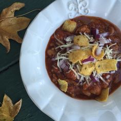 a white plate topped with chili and cheese