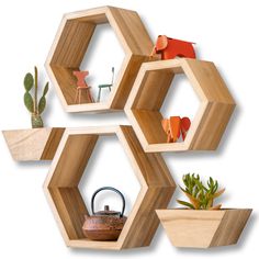 three wooden hexagonal shelves with pots and plants on them, one holding a teapot