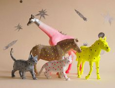 three toy animals standing next to each other in front of a wall with stars on it