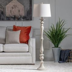 a living room with a couch, lamp and painting on the wall behind it in an apartment