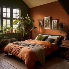 a bedroom with an orange bed and green plants on the wall, along with wooden flooring