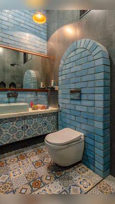 a bathroom with blue and yellow tiles on the walls, toilet seat cover and sink