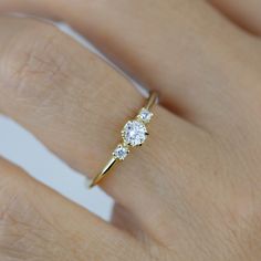 a woman's hand with a diamond ring on top of her finger and an engagement band