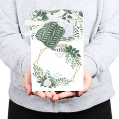 a person holding up a card with leaves on it