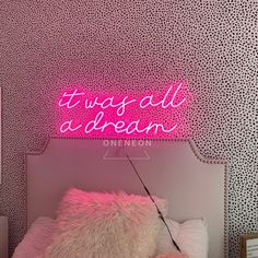 a neon sign that says it was all a dream on the wall above a bed