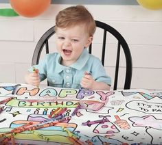 a young boy sitting at a table in front of a birthday cake with the words happy birthday written on it