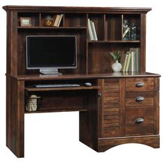 a wooden desk with a computer monitor and drawers