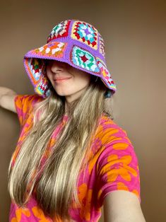 a woman with long blonde hair wearing a colorful hat