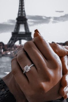 a woman's hand holding the eiffel tower in front of her face