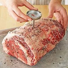 a person is using a meat thermometer to measure it on a piece of meat